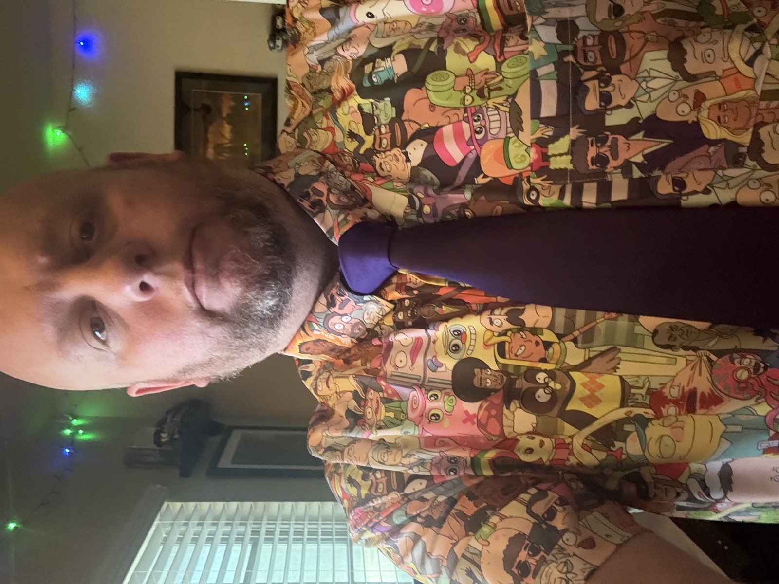 Jeremy D. Pretty wearing a colorful pop-culture patterned shirt and purple tie.