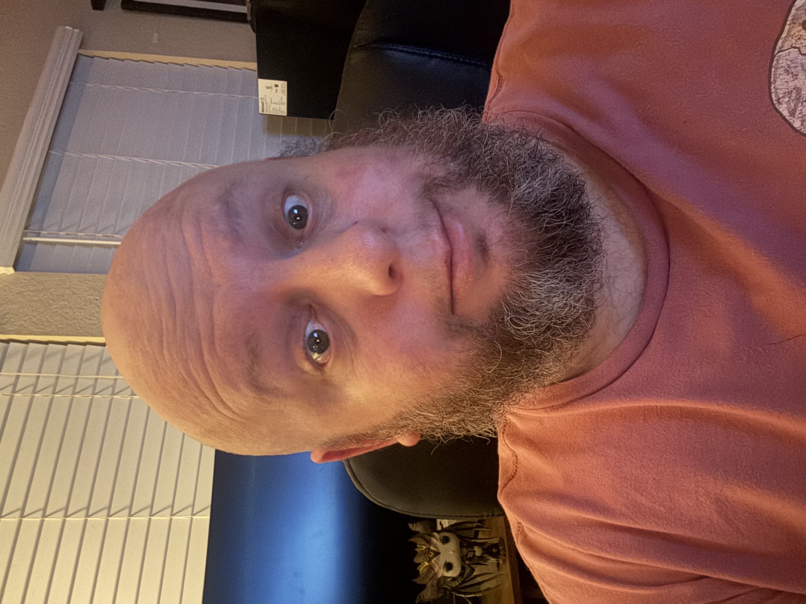 Jeremy D. Pretty wearing a coral shirt in a workspace.