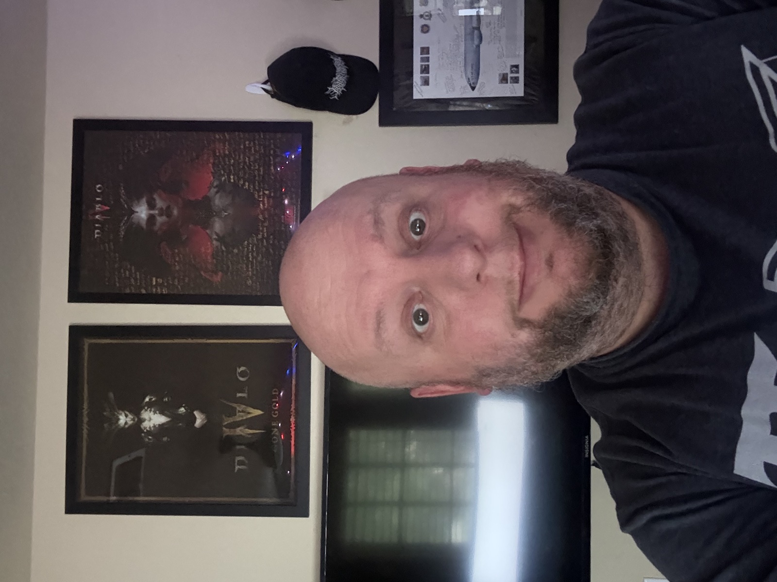Jeremy D. Pretty in a dark shirt with framed Diablo artwork visible behind him.